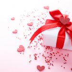 White gift box with hearts on pink background